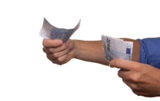 Ein Mensch, von dem nur die Arme zu sehen sind, hält mehrere 20 Euro-Scheine ins Bild.