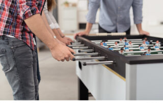 Kollegen beim Tischkicker spielen.