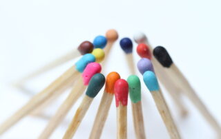 Streichhölzer mit farbigen Spitzen, die zu einem Kreis zusammengestellt sind.