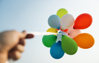 Zusammengebundene Luftballons gen Himmel fotografiert.