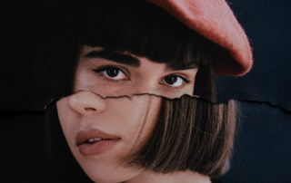 Porträt einer jungen Frau mit braunen kurzen Haaren und Barett