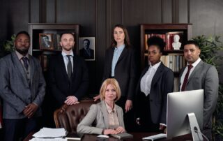 Ein Führungsteam steht um einen Schreibtisch bei einem Teambuilding.