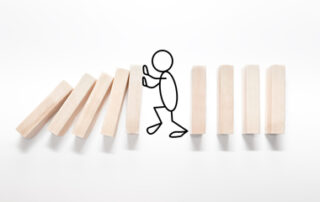 Ein Strichmännchen schiebt Holzstäpchen als Intervention in einer Organisation.